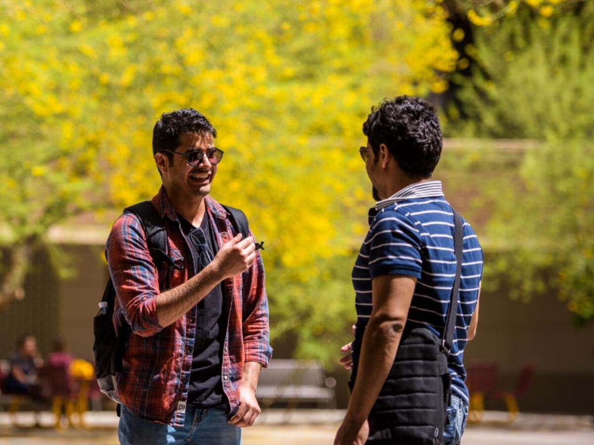 Two people conversing on campus