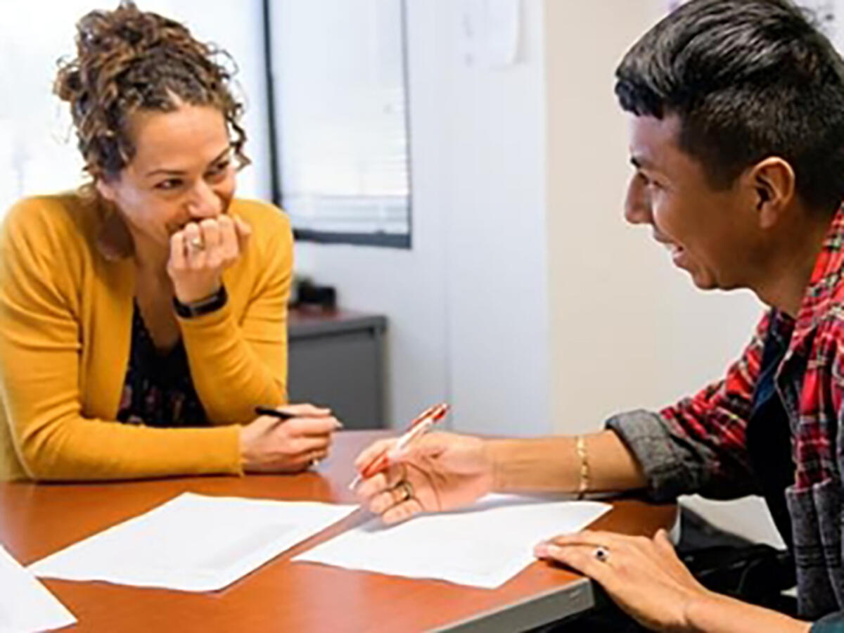 Two people sitting at meeting room table